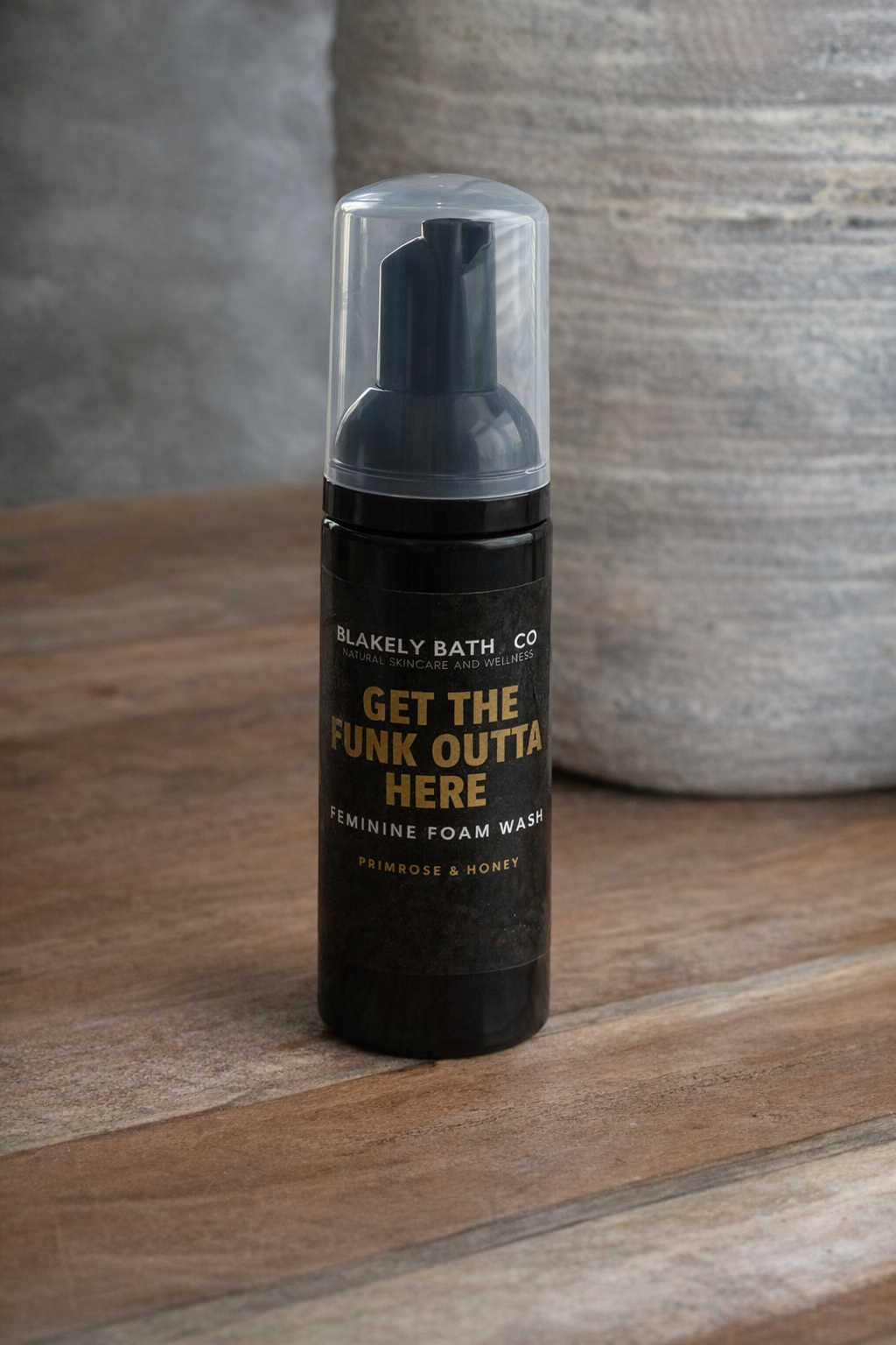Foam wash bottle with text on a wooden surface