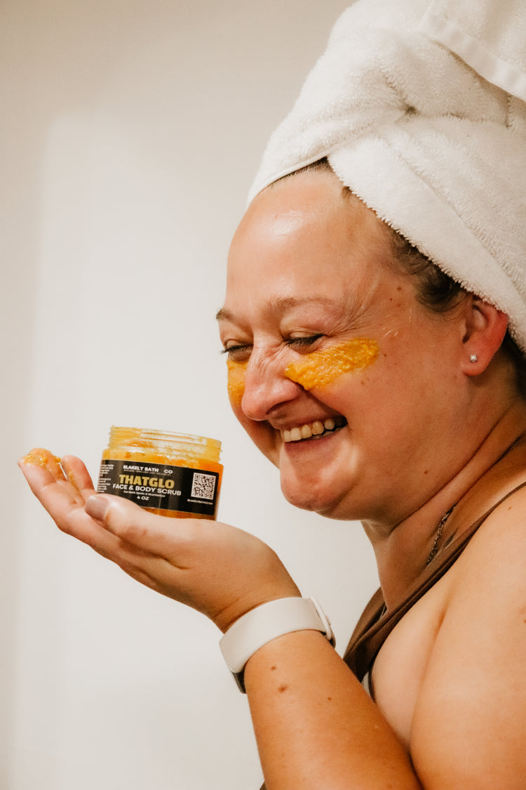 Woman applying turmeric face and body scrub on face — dark spot remover collection by Blakely Bath & Co.