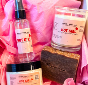 Hot Girl Valentine Set displayed with a soap bar, multipurpose spray, body butter, and candle. A luxurious self-care bundle with warm notes of salted caramel, vanilla, sandalwood, and pistachio - Blakely Bath & Co