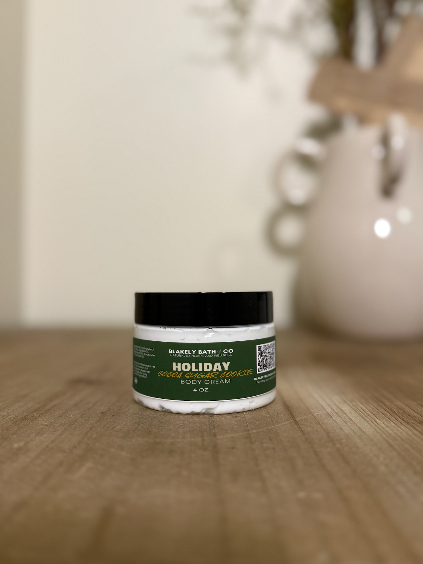 Jar of body cream with green label on a wooden surface