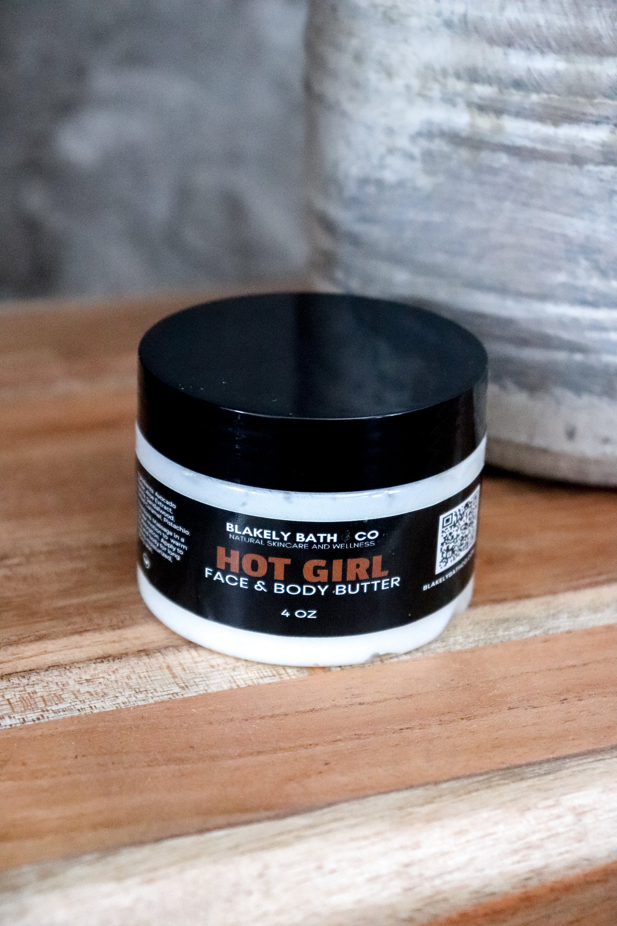 Jar of Hot Girl face and body butter by Blakely Bath Co on a wooden surface.