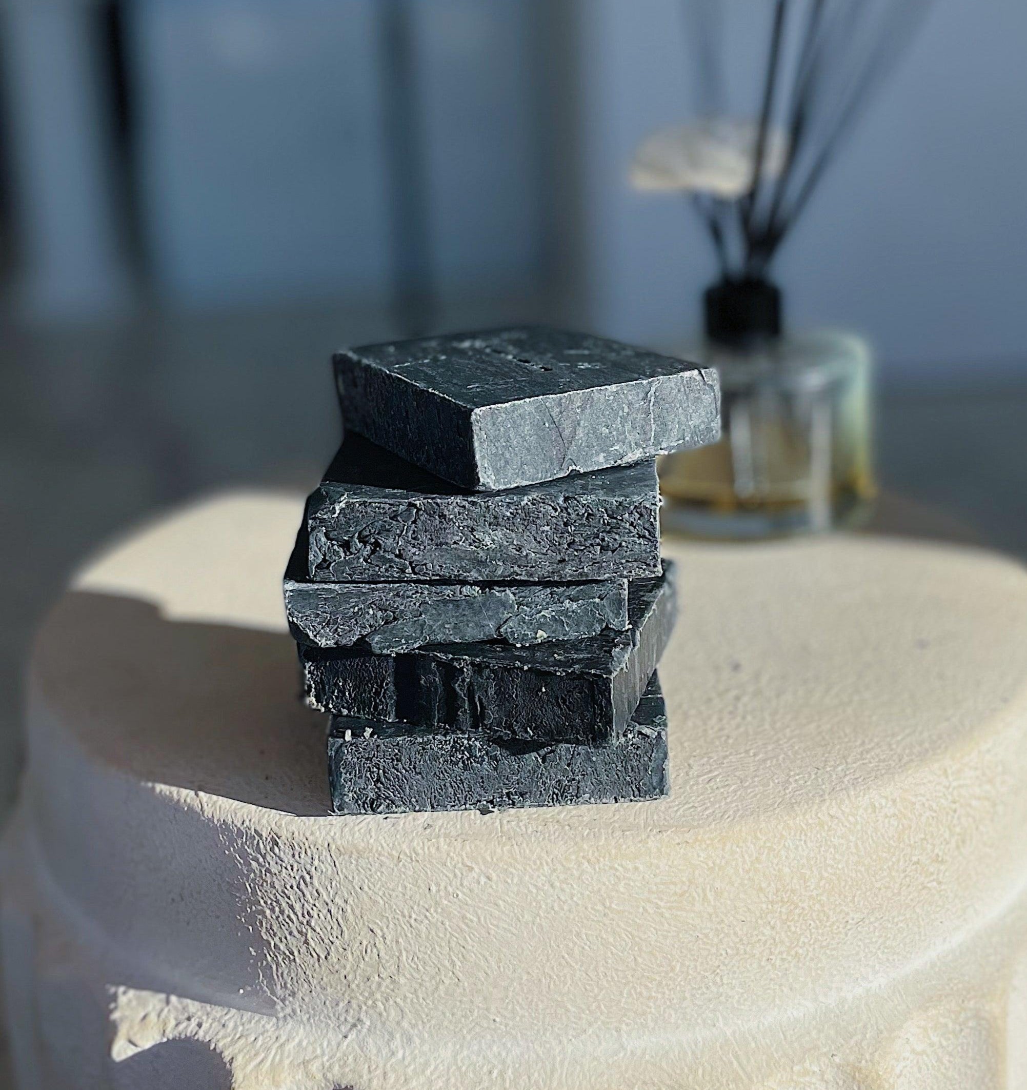 Stack of Lavender Charcoal Soaps by Blakely Bath & Co for detoxifying and soothing oily skin and acne, infused with calming lavender and activated charcoal to purify and cleanse deeply