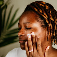 Black woman applying Silk Dream Cream to the face – natural skincare moisturizer for radiant, youthful, silky smooth skin.