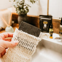 Holding Soap Saver Sack with lavender charcoal soap bar near sink by Blakely Bath & Co
