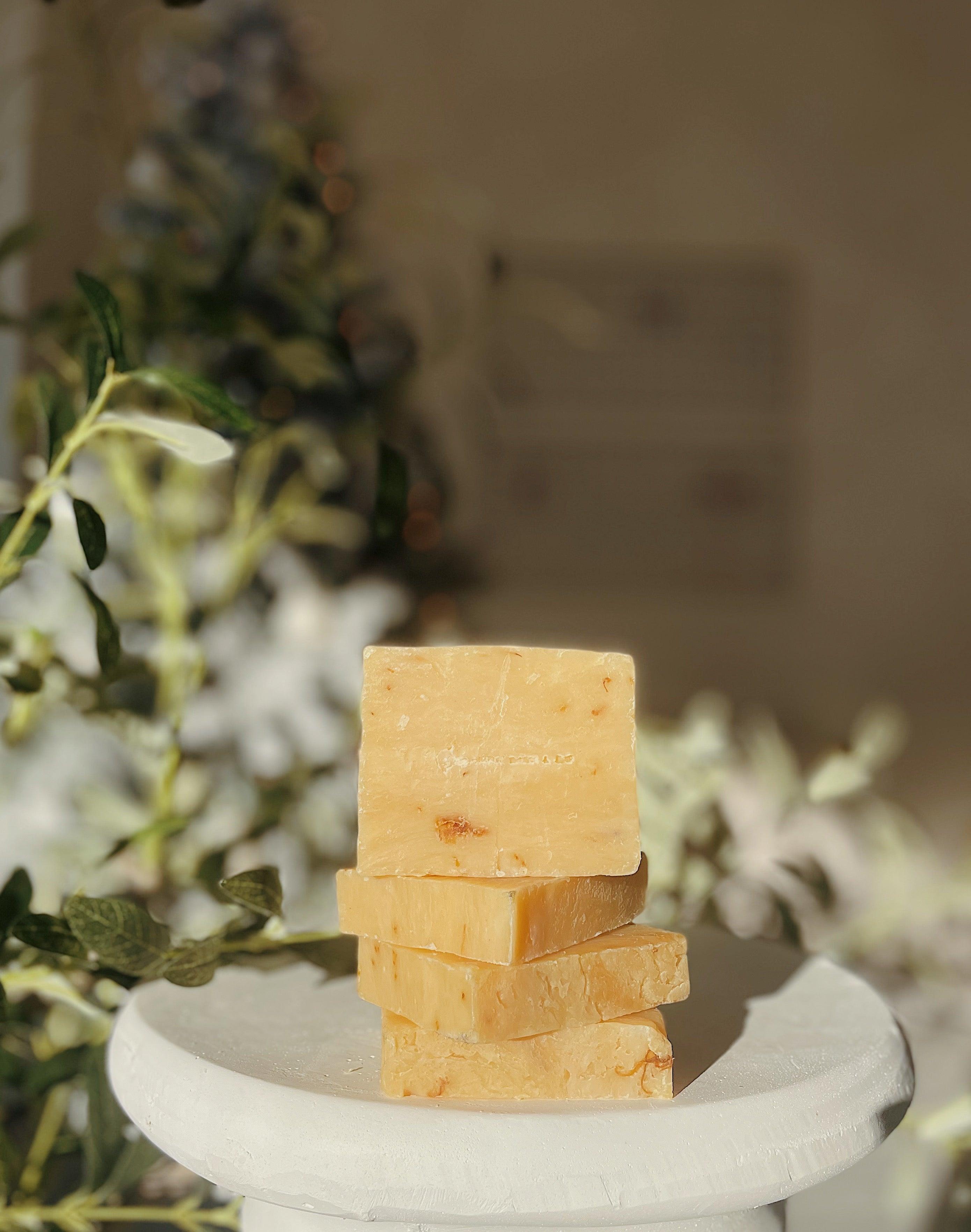 Stack of ThatGlo Turmeric Soap Bars by Blakely Bath & Co, a natural soap infused with turmeric to brighten skin, reduce dark spots, and promote a glowing complexion