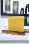 Thatglo Turmeric + calendula  bar of soap on a wooden soap dish by Blakely Bath & Co 