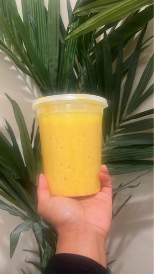 Hand holding bulk size Turmeric brightening scrub for face and body by Blakely Bath and Co