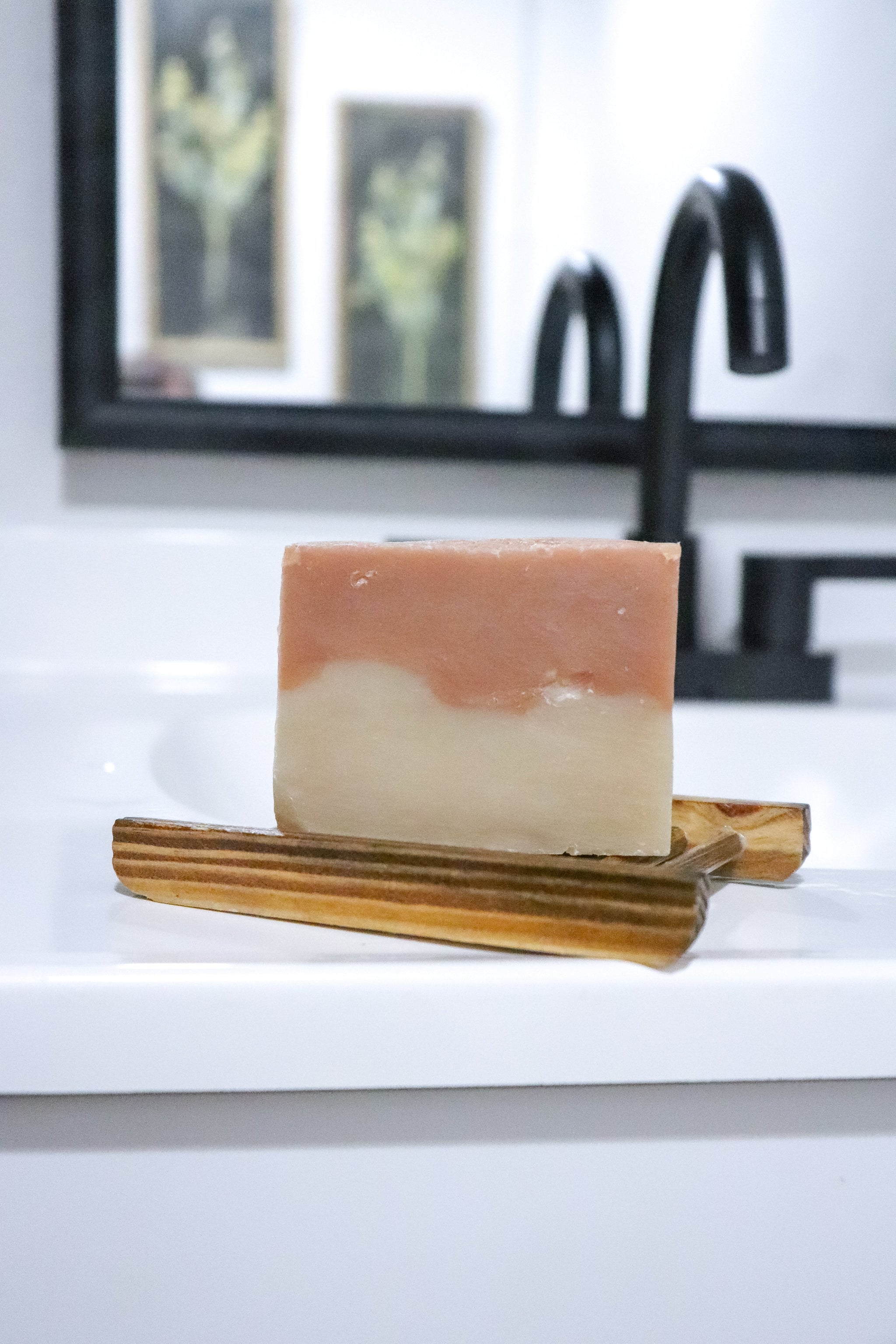Cherry Almond soap bar by Blakely Bath and Co of soap on a wooden soap dish with a blurred bathroom background