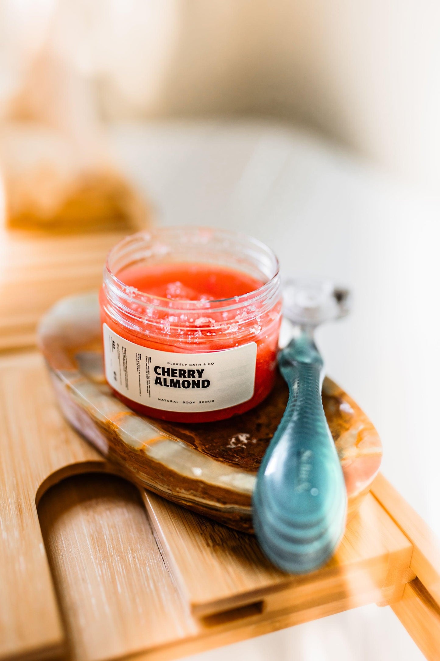 Blakely Bath & Co Cherry Almond Body Scrub paired with a razor, perfect for a smooth shave, exfoliating and softening skin while leaving behind a sweet cherry almond scent