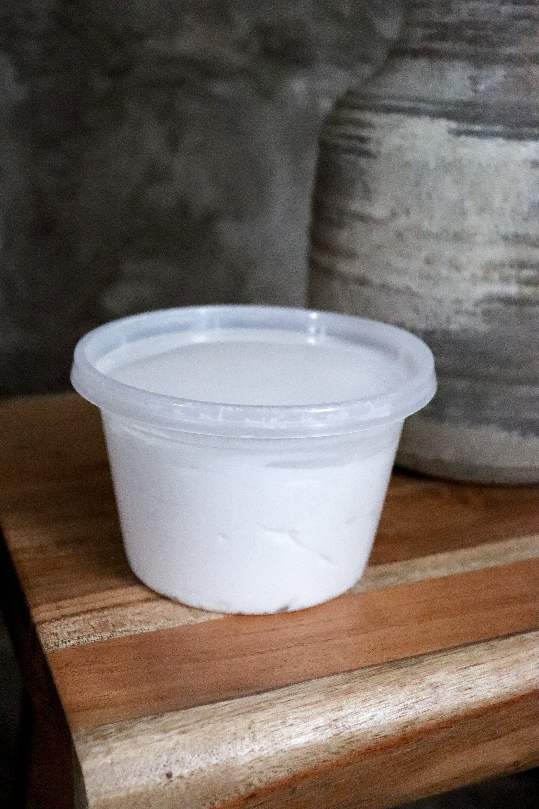 Family size clear PET plastic container of Silk Dream Cream by Blakely Bath and Co on a wooden surface