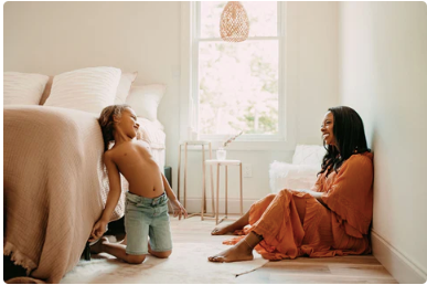 Sade Campbell, BSN, RN, mother and founder of Blakely Bath & Co., sitting with her son Eli, who has eczema, in a warm, natural setting. A heartfelt moment showcasing their journey and commitment to gentle, skin-loving care.