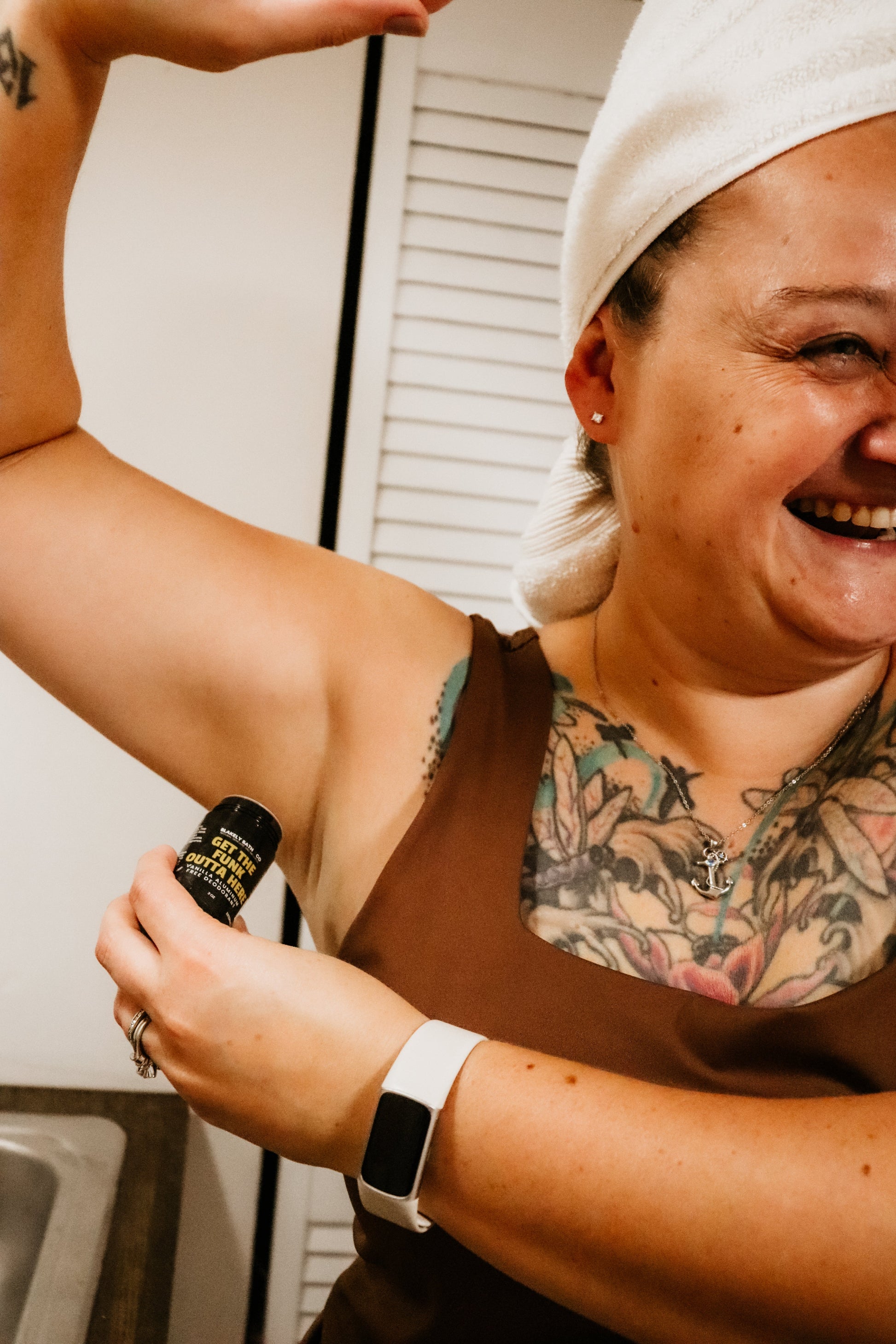 woman with tattoos holding Blakely Bath & Co's Vanilla Aluminum-Free Deodorant in her hand, showcasing the compact, natural, long-lasting deodorant with a soothing vanilla scent for all-day freshness