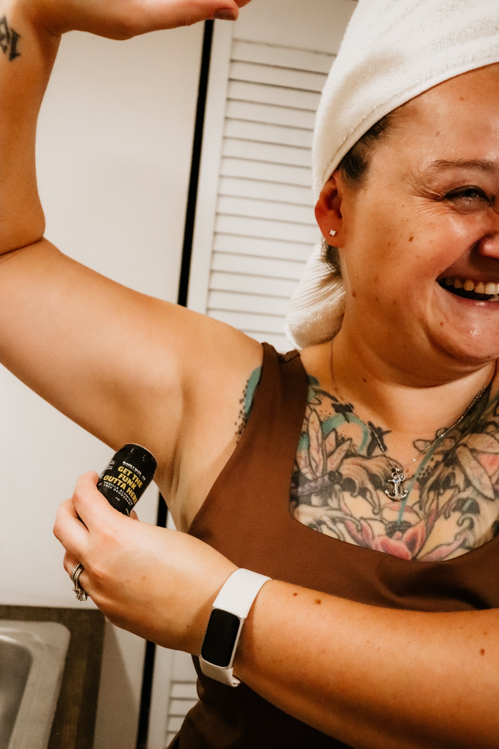 woman with tattoos holding Blakely Bath & Co's Vanilla Aluminum-Free Deodorant in her hand, showcasing the compact, natural, long-lasting deodorant with a soothing vanilla scent for all-day freshness