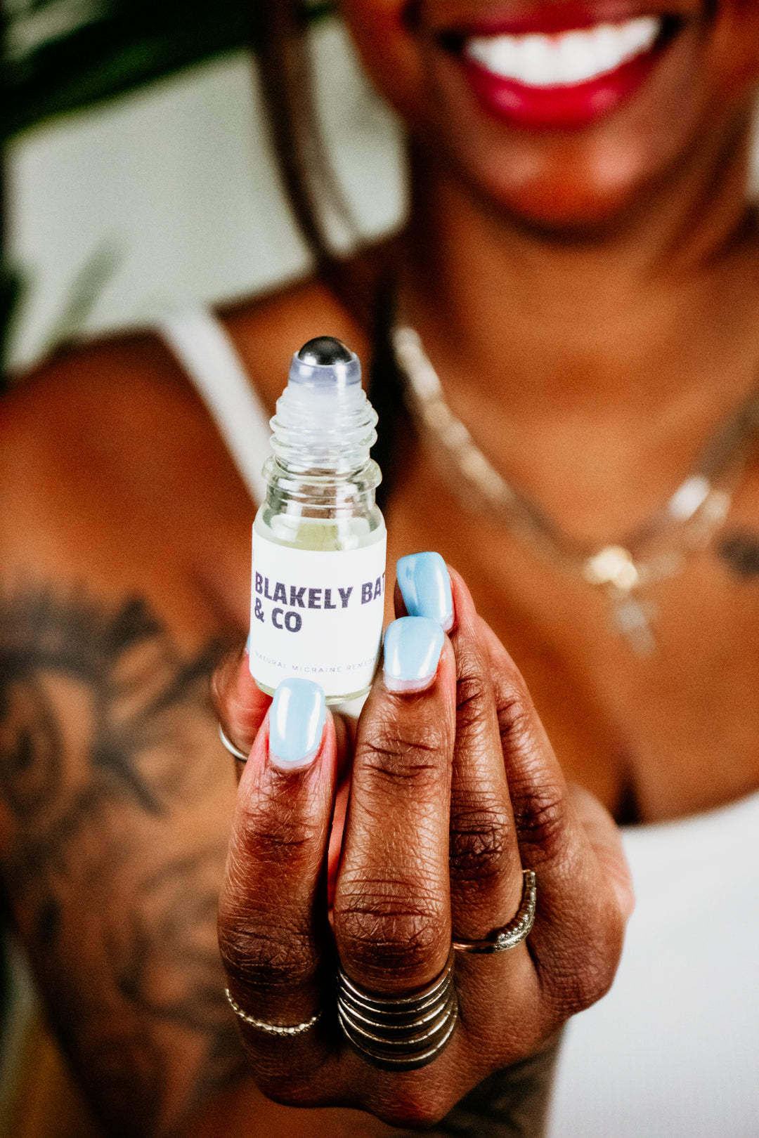 Sade Campbell, owner of Blakely Bath & Co, holding the Migraine Relief Roller, ready to apply the natural blend of essential oils to ease headaches, tension, and migraines"