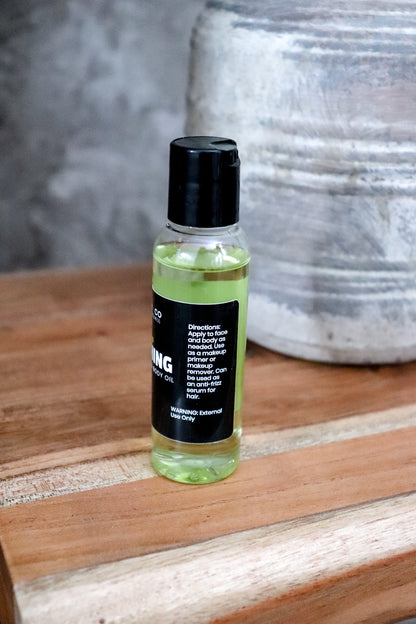 Small bottle of Nourishing face and body oil with black cap showing directions on a wooden surface