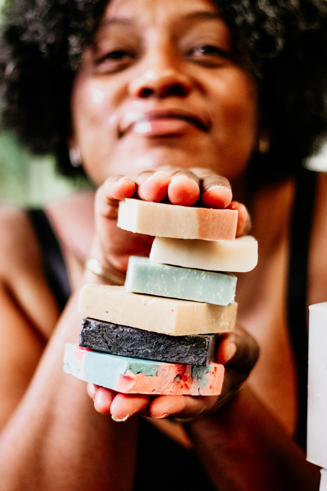 Smiling woman holding a natural bar soap by Blakely Bath & Co, promoting the Soapscription program for Soapscribe members, featuring eco-friendly, skin-nourishing soap bars delivered regularly