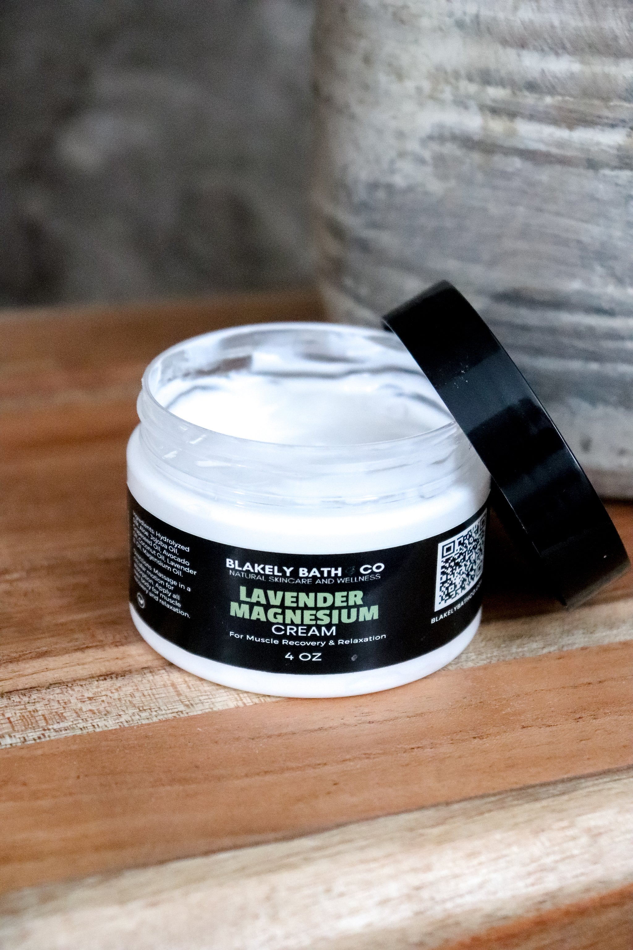 Jar of Blakely Bath & Co Lavender Magnesium on a wooden surface with top off