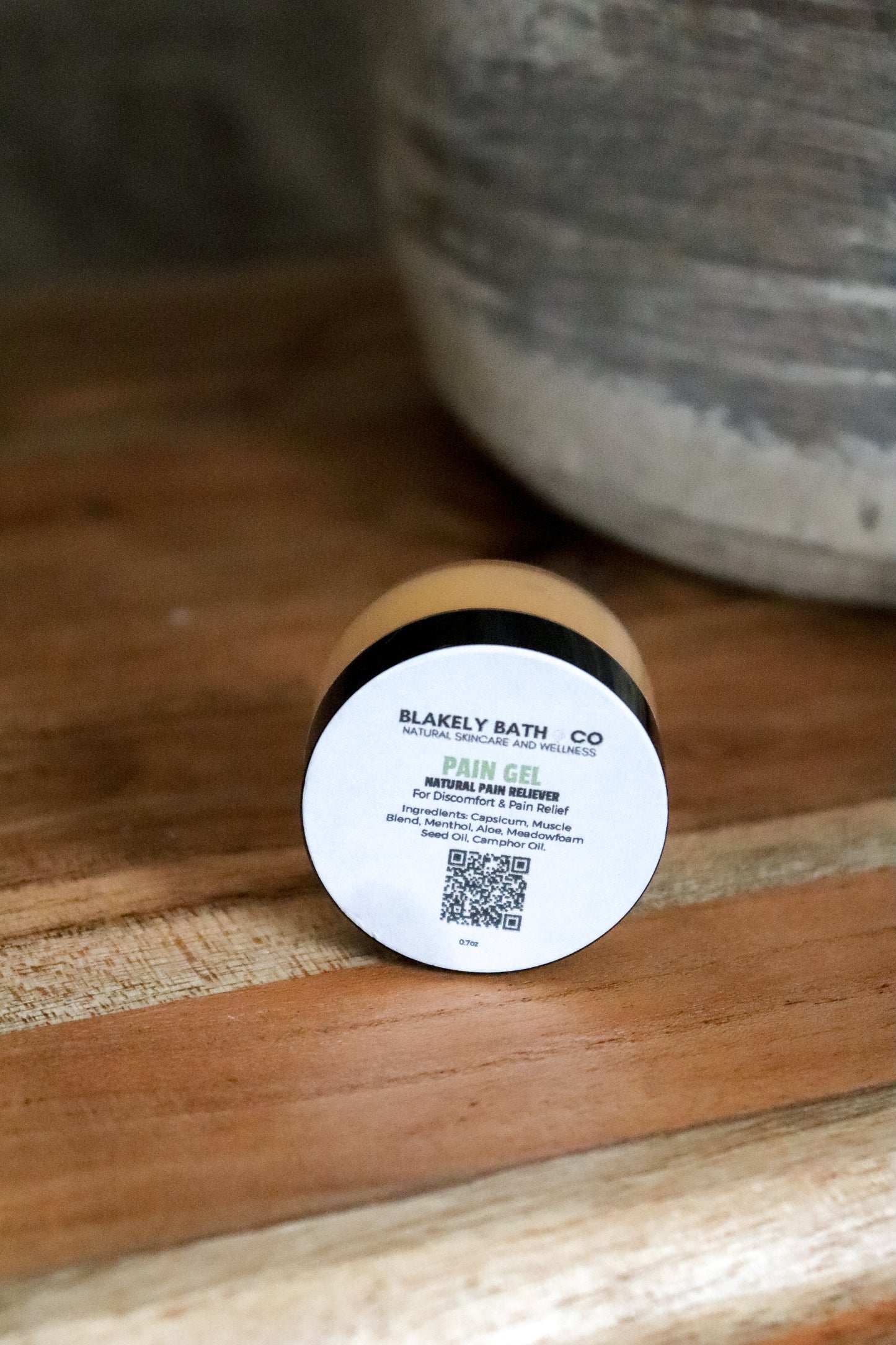 Pain gel container with label on a wooden surface