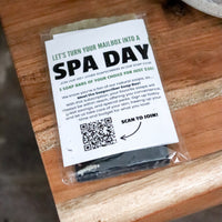 Promotional postcard for a 'Spa Day'  soapscription by Blakely Bath and Co on a wooden surface with a QR code.