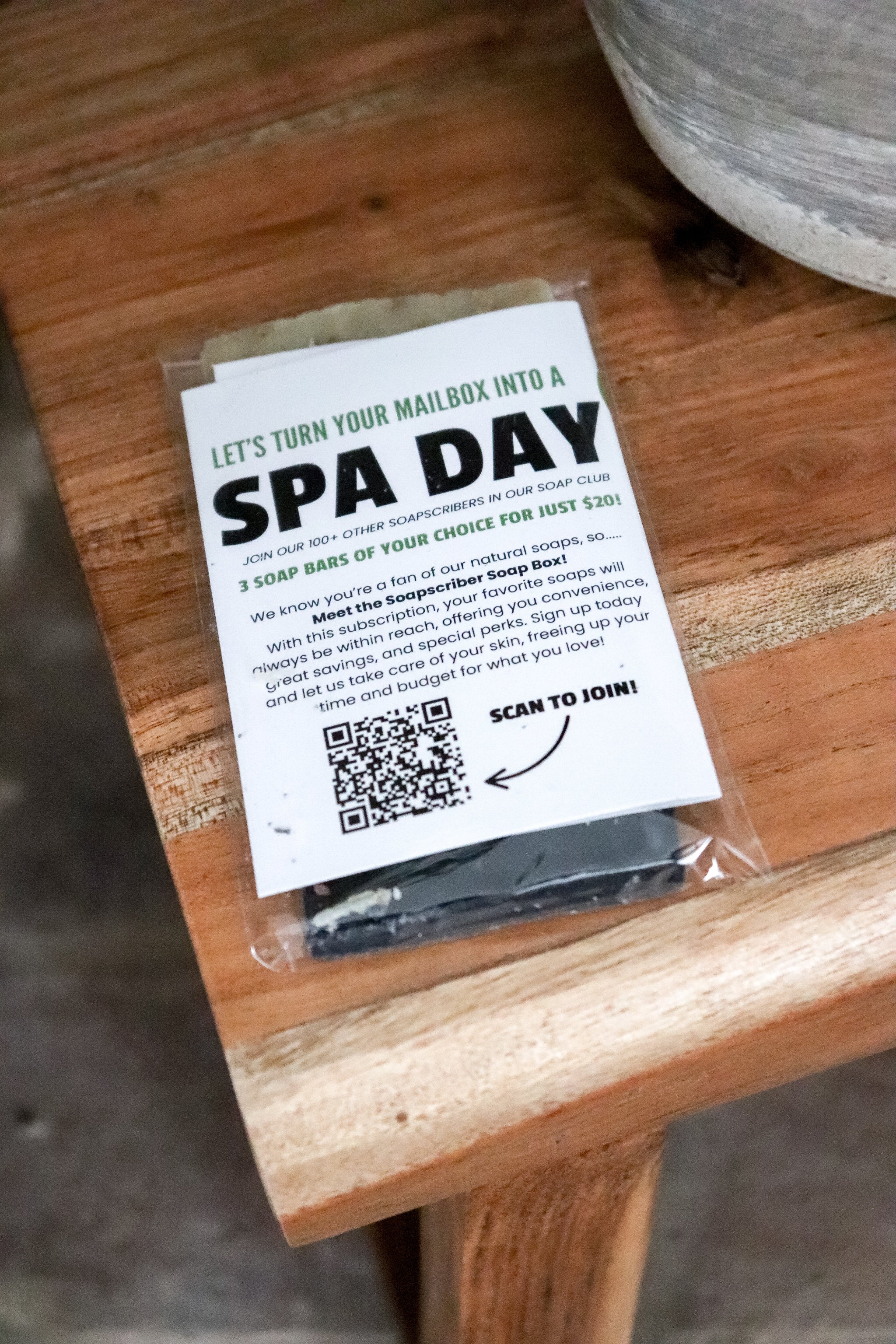 Promotional postcard for a 'Spa Day'  soapscription by Blakely Bath and Co on a wooden surface with a QR code.