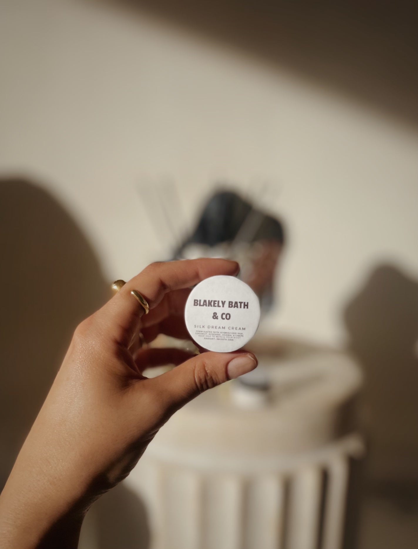 Girl holding small container of silk dream moisturizing cream