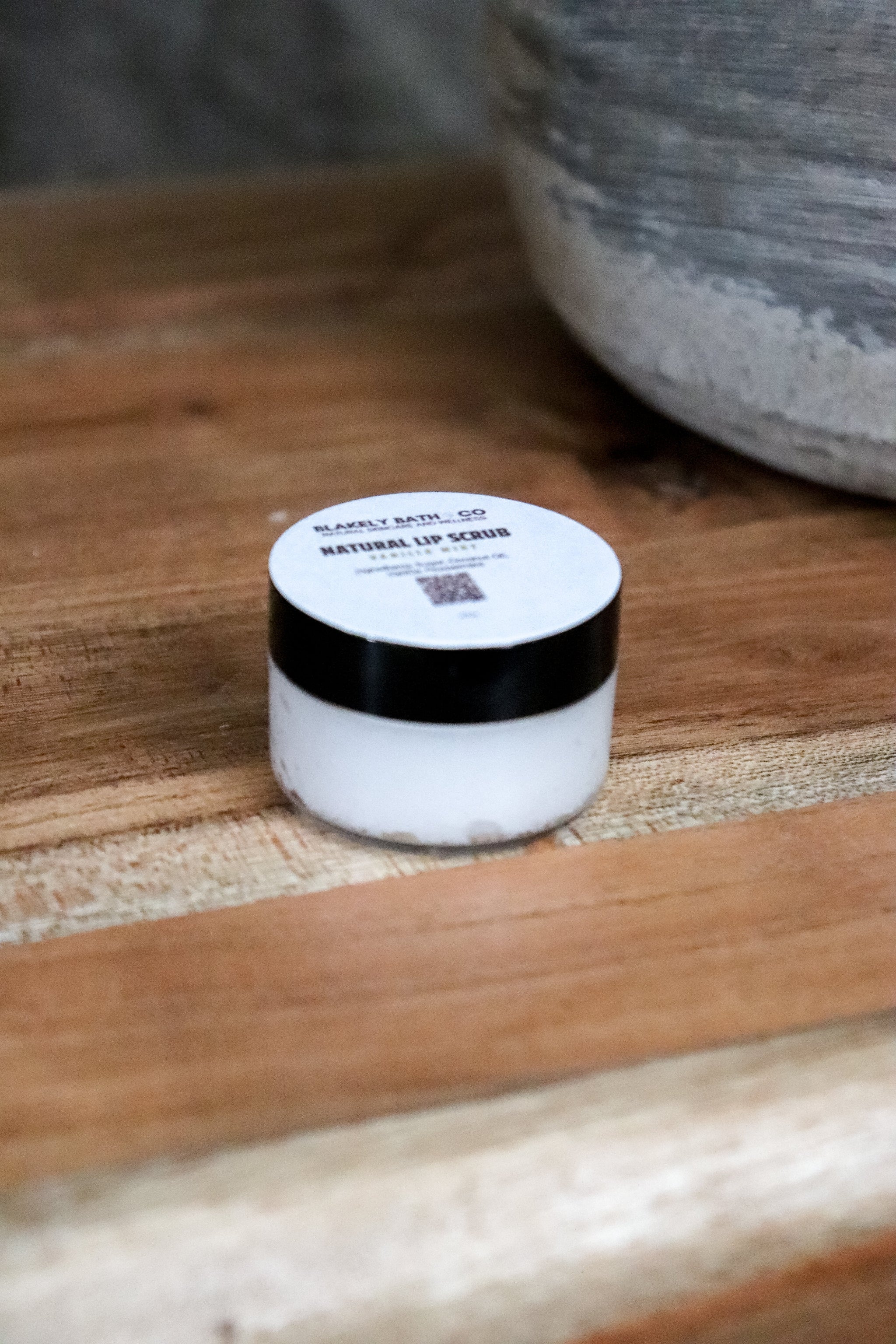 Blakely Bath & Co Vanilla Mint Lip Scrub, a natural exfoliating scrub on wooden table