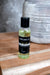 Bottle of Nourishing Face and body oil  on a wooden surface with a blurred background by Blakely Bath & Co 