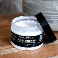 Jar of Silk Dream face and body cream on a wooden surface with a neutral background
