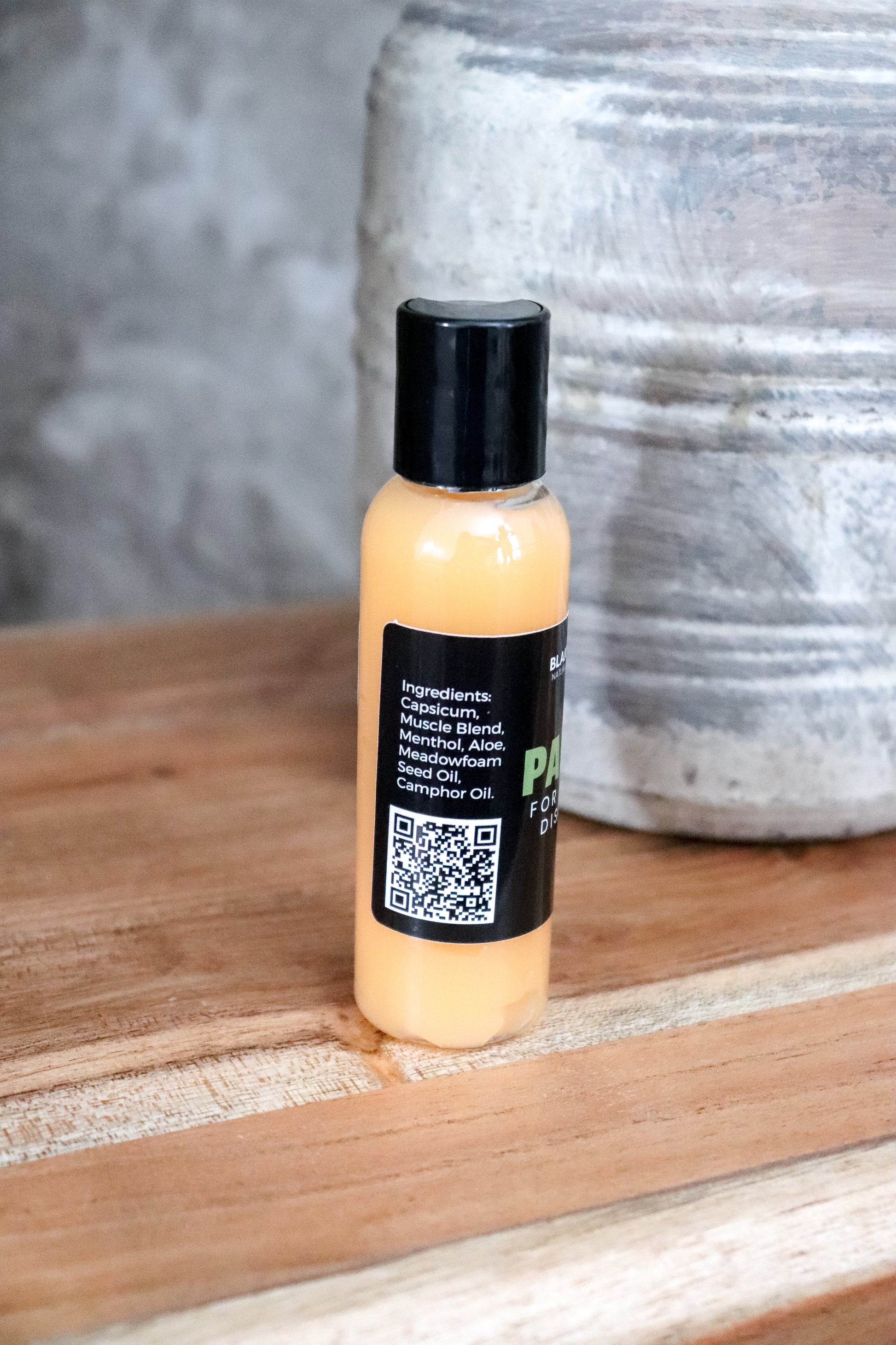 Bottle of Pain Relief Gel from Blakely Bath & Co with a easy scannable QR code label on a wooden surface