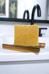 Bar of Pomegranate Pear Exfoliation soap bar  on a wooden soap dish 