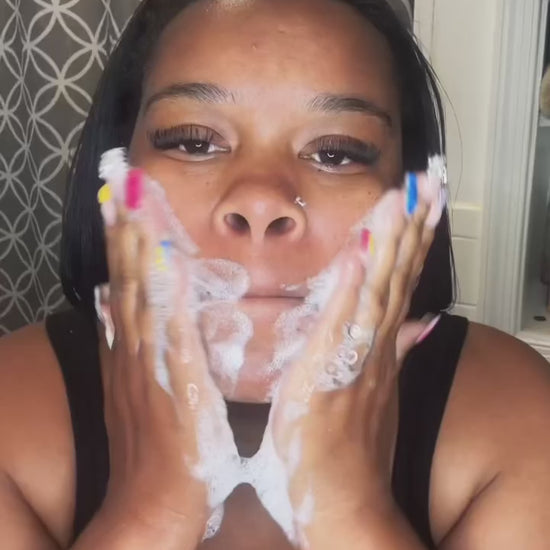 Black woman washing her face with a goat milk soap bar – gentle, moisturizing, and perfect for sensitive or eczema-prone skin.