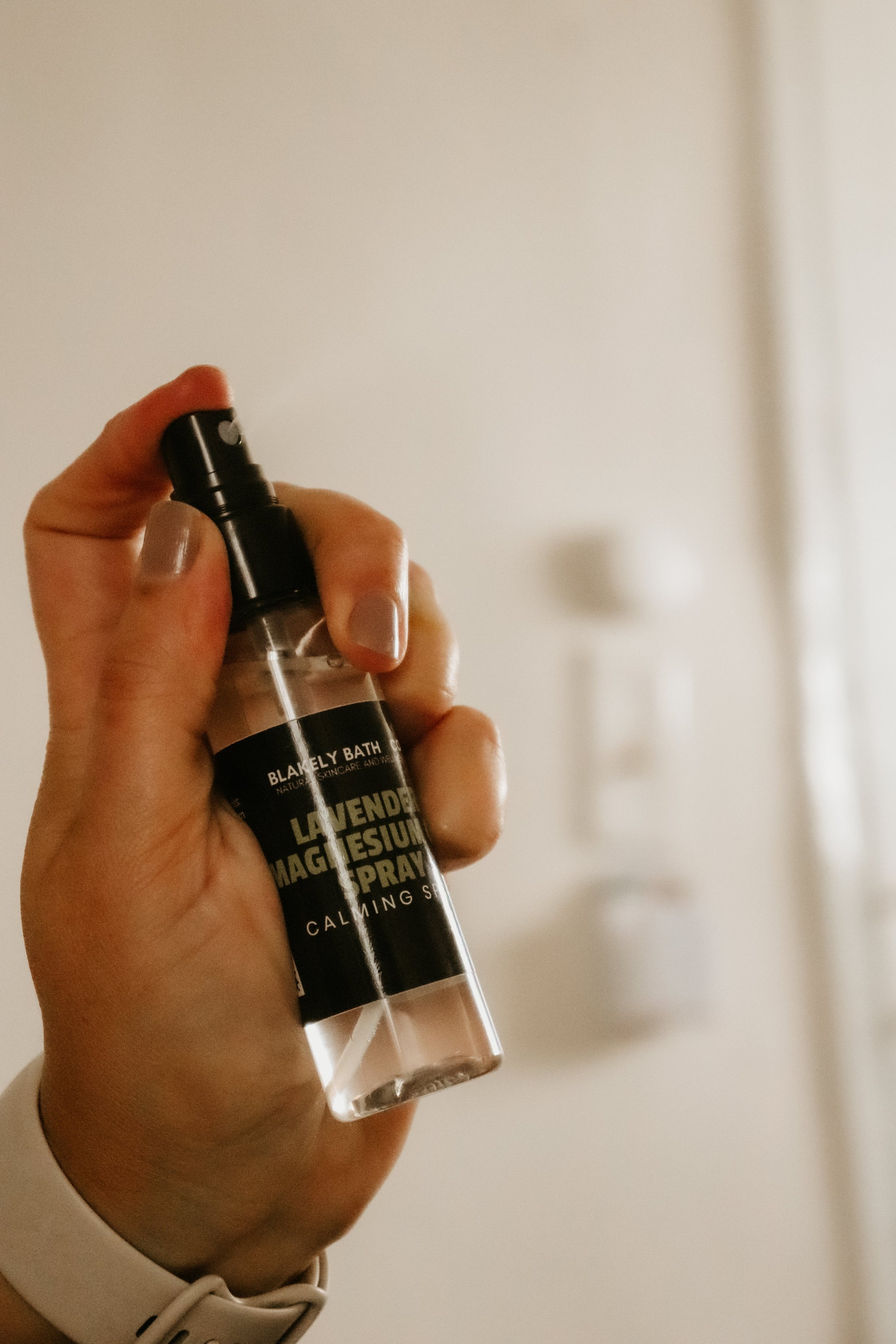 Hand holding a bottle of 'Blakely Bath & Co Lavender magnesium spray 