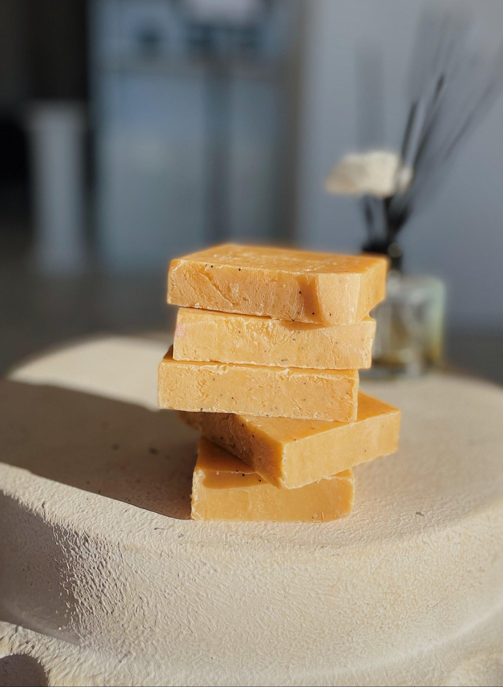Stacked Pomegranate Pear Exfoliation Soap bar sitting on table 