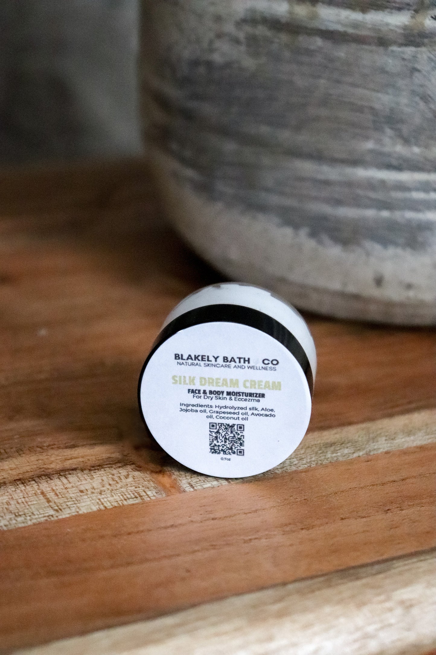 Travel size jar of Silk Dream Cream by Blakely Bath & Co label on a wooden surface