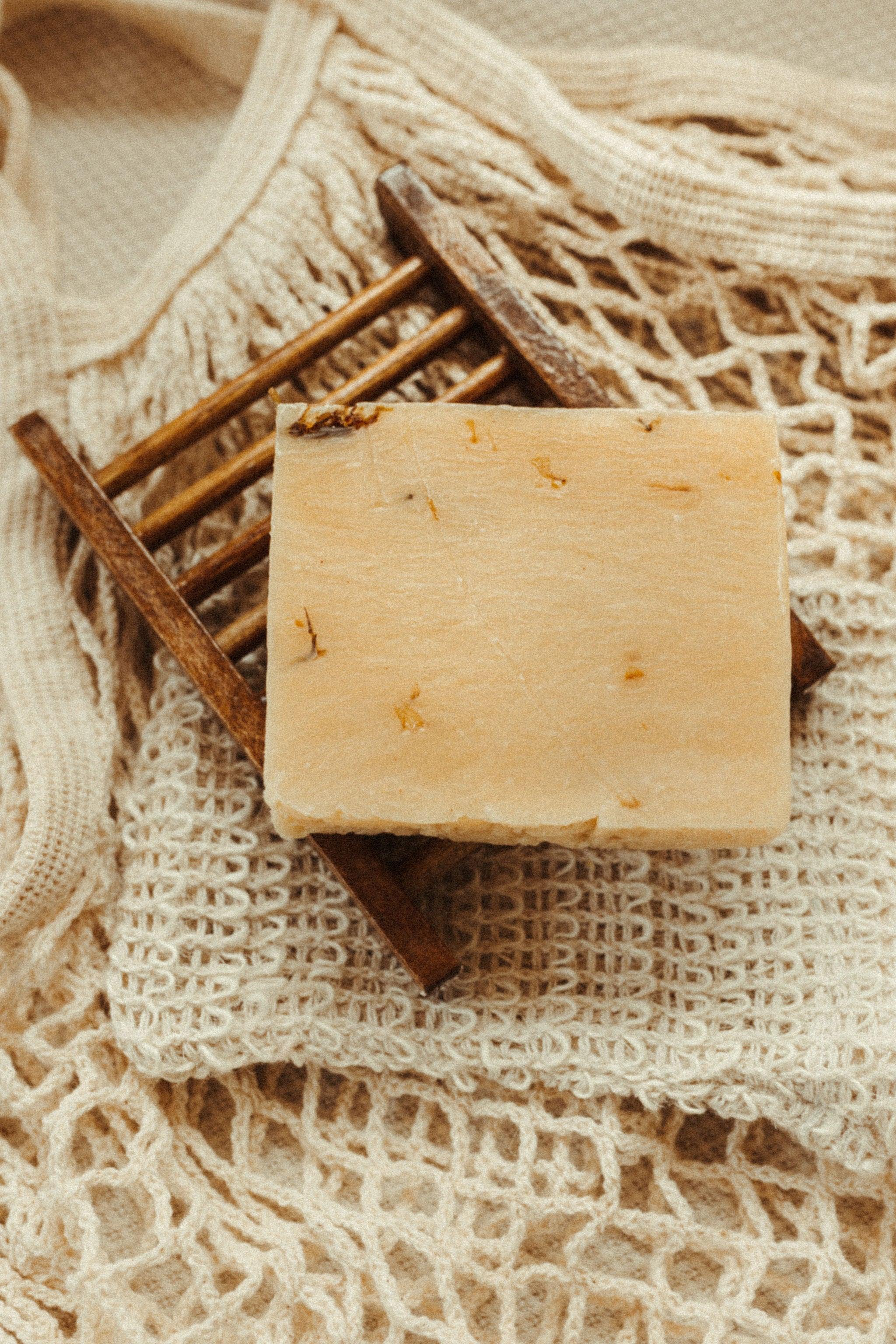 Blakely Bath & Co Eco-Friendly Bamboo Soap Dish holding turmeric soap bar, offering a sustainable solution to keep your soap dry and extend its life, with a natural, minimalist design