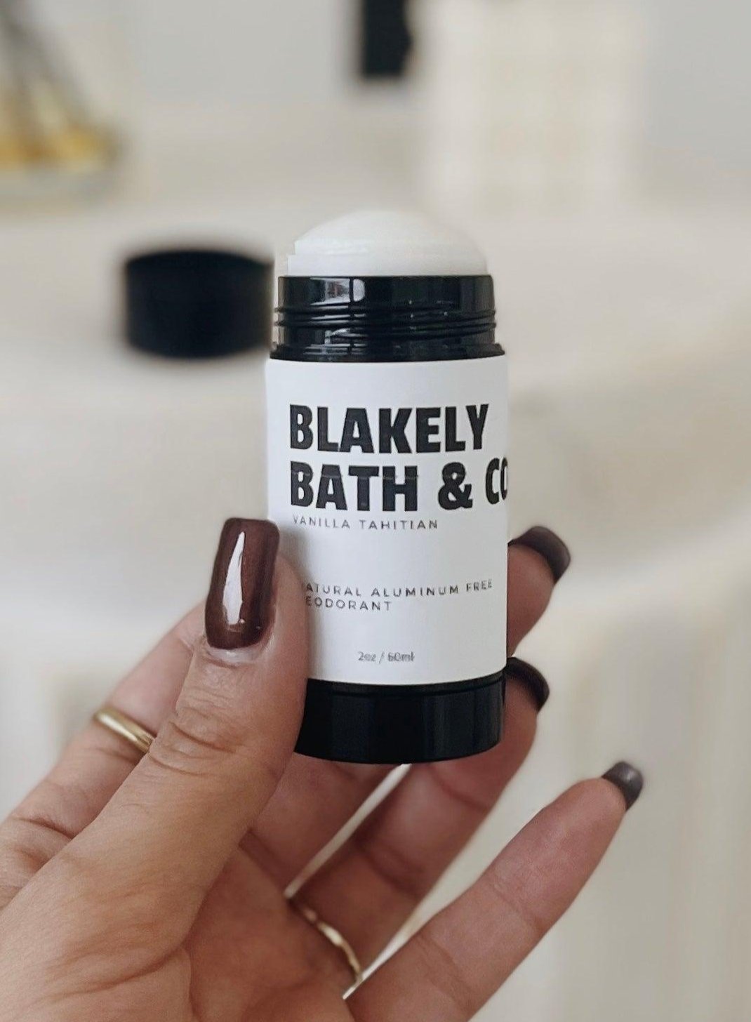 Tessa Chaplin holding Blakely Bath & Co's Vanilla Aluminum-Free Deodorant in her hand, showcasing the compact, natural, long-lasting deodorant with a soothing vanilla scent for all-day freshness