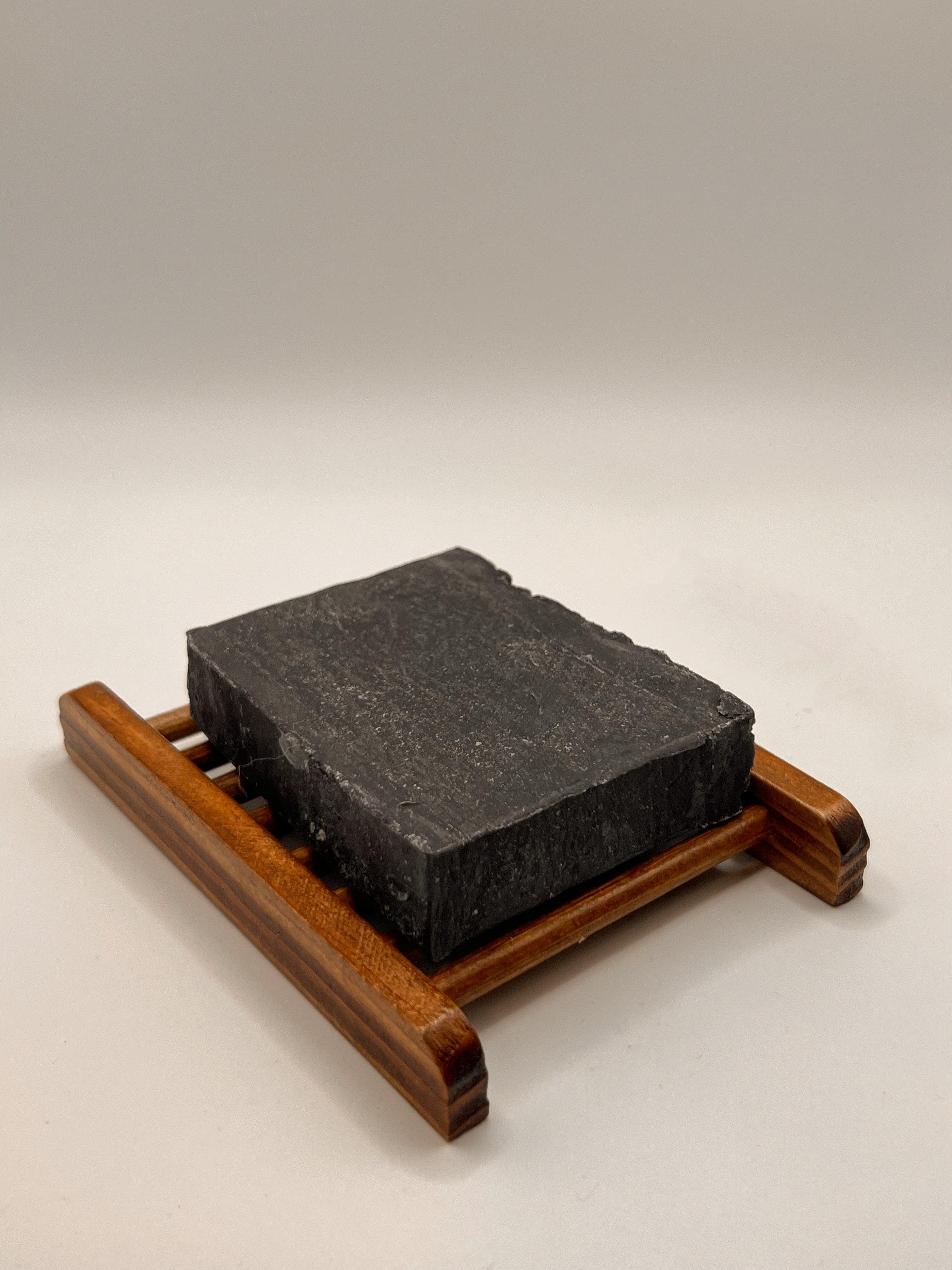 Blakely Bath & Co Eco-Friendly Bamboo Soap Dish holding a lavender charcoal soap bar, offering a sustainable solution to keep your soap dry and extend its life, with a natural, minimalist design