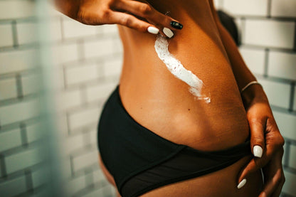 Amber Rothgeb applying Hot Girl Face and Body Butter by Blakely Bath & Co to her skin, experiencing deep hydration, smoothness, and a glowing, bum bum scented finish